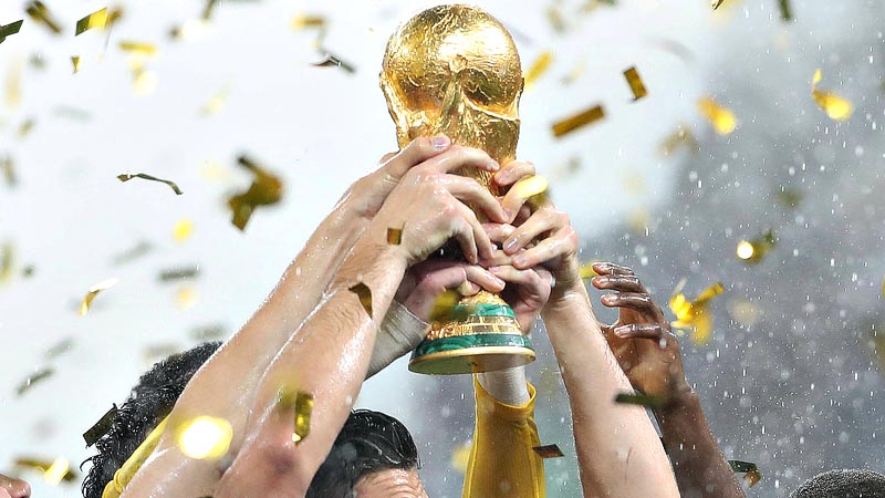 Hände halten den WM-Pokal im Konfettiregen